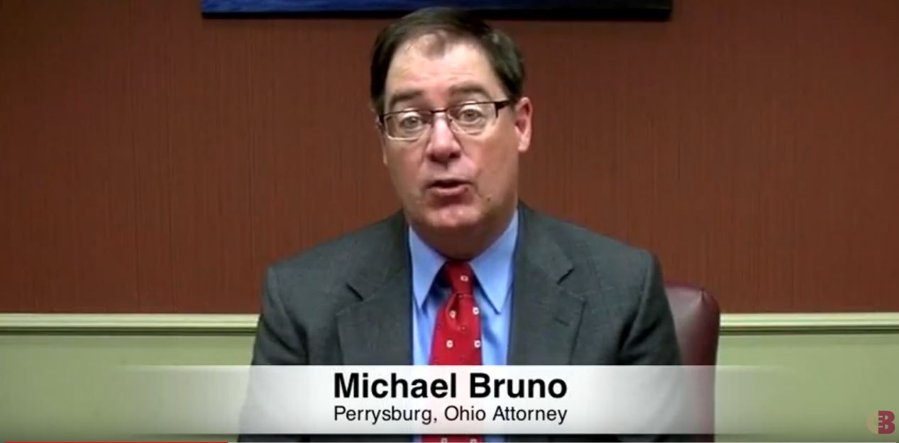 Michael Bruno sitting and speaking, and a text at bottom with his name