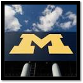 sign with the University of Michigan logo on it, blue sky and clouds in the background